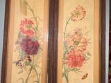 two framed pictures of flowers on the wall in the room