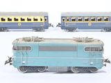 three toy trains sitting side by side on a white surface