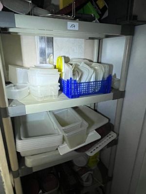 une étagère sur laquelle sont posés de la vaisselle et des récipients, dans une cuisine
