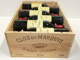 bottles of red wine in a wooden box on a table