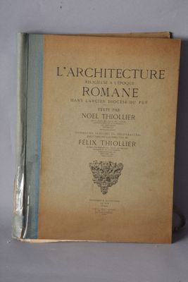 an old book sitting on top of a table next to a white wall