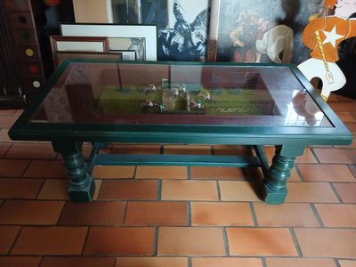 une table avec un plateau en verre posée sur un sol carrelé