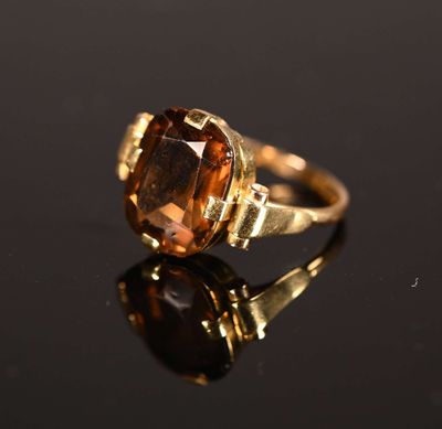 un gros plan d'une bague avec une pierre marron sur un fond noir