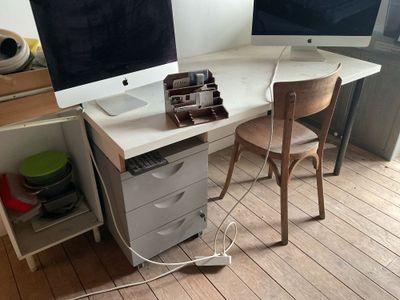 un bureau avec deux écrans et une chaise placée devant