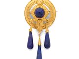 a close up of a gold broochle with blue drops