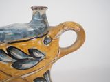 a yellow and blue vase with a bird on it