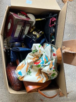 une boîte en carton remplie d'objets divers, posée par terre