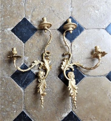 une paire d'appliques murales posées sur un sol carrelé