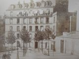 an old photo of a large building with a clock on it