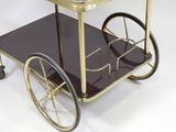 a gold and black bar cart with a glass top