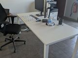 a white desk with a computer on it and a black chair