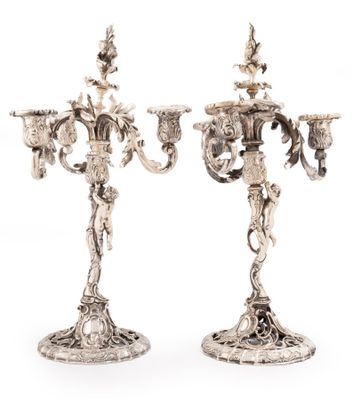 une paire de chandeliers en métal argenté ornés de fleurs et de feuilles