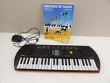 a keyboard that is sitting on a table next to a book
