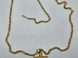 a gold necklace with a cross on it