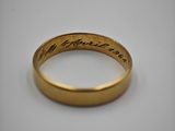 a close up of a gold wedding ring with handwriting on it