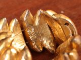 a close up of a gold brooch on a table
