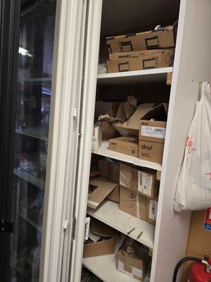un réfrigérateur sur lequel sont posées de nombreuses boîtes, dans une pièce