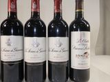 six bottles of red wine are lined up on a shelf