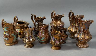 six pieces of antique brass vases are lined up on a gray surface