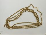 a close up of a gold chain on a white surface