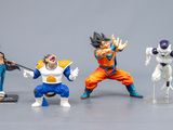 Des figurines Dragon Ball sont exposées sur une surface grise