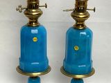 une paire de lampes en verre bleu avec des pieds en laiton, sur fond blanc