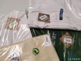 a pile of t - shirts on a table with labels on them