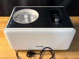 une machine blanche et noire posée sur une table en bois