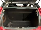 a red car with its trunk open in the back of the car