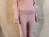 Le mannequin porte un pull rose et un legging.