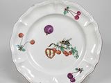 une image représentant une assiette blanche ornée d'un motif représentant un oiseau et des fruits