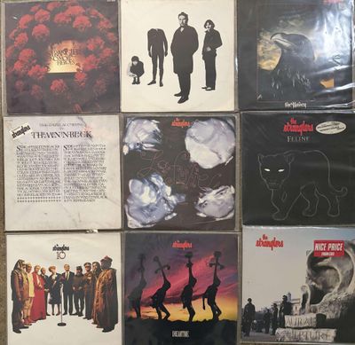 many different album covers on the wall of a room