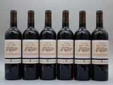 six bouteilles de vin sont alignées sur une table
