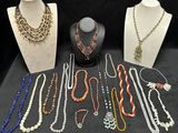 many necklaces and bracelets on display on a table