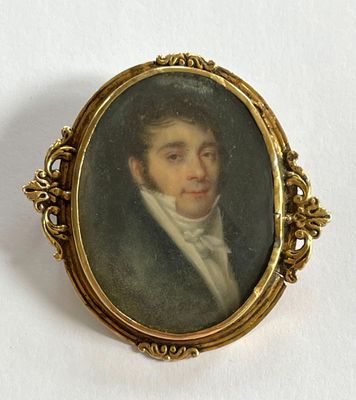 un portrait ancien représentant un homme en costume et cravate, dans un cadre doré