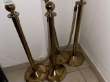four brass candles that are on the floor next to a wall