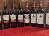 several bottles of wine are lined up on a red cloth