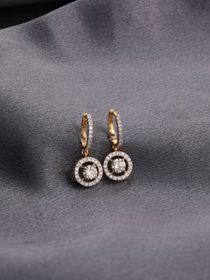 a pair of gold and diamond earrings on a gray cloth