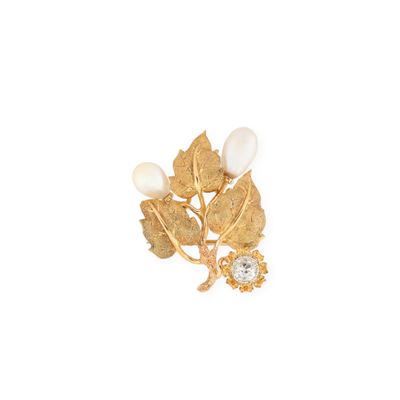 une image représentant une broche en or ornée de perles et de feuilles