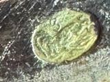 a close up of a piece of metal with a coin on it