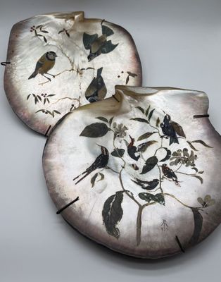 two decorative plates with birds on them on a table