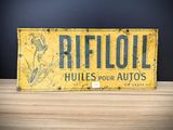 an old yellow and black sign sitting on top of a wooden table