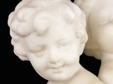 two statues of a boy and a girl on a black background