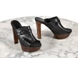 une paire de chaussures en cuir noir posée sur une table en marbre, sur fond blanc
