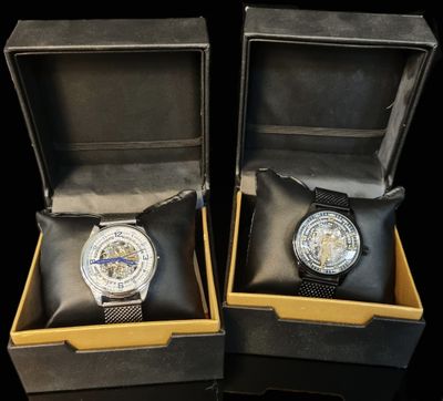 pair of watches in a box on a black surface