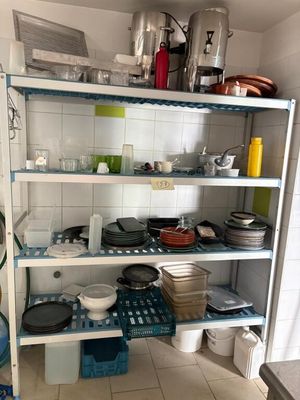 many pots and pans on the shelves in the kitchen