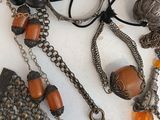 many different necklaces and bracelets that are on a table