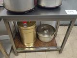 two pots and a pan on a table in a kitchen