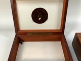 two wooden boxes with a clock inside of them on a white surface