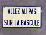 un panneau de signalisation bleu et jaune fixé sur le mur d'un immeuble